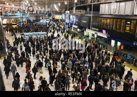Rush Hour pendolari attendere il prossimo treno Informazioni di arrivo alla stazione ferroviaria di Waterloo a Londra. Novembre 2018 Foto Stock