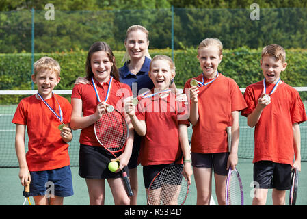 Ritratto di scuola vincente squadra di tennis con medaglie Foto Stock