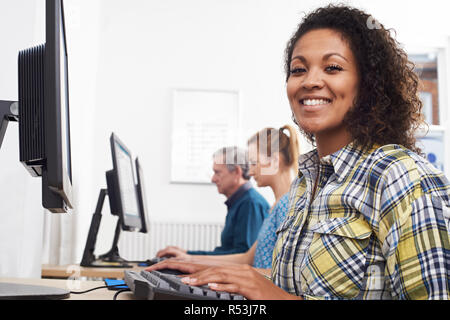 Ritratto di giovane donna che frequentano la classe di computer nella parte anteriore dello schermo Foto Stock