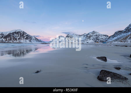 Tramonto e nevoso inverno in montagna in Skagsanden beach nei pressi di Flakstad, Lofoten, Norvegia Foto Stock