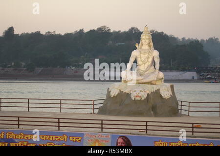 Dio indù Shiva statua a Rishikesh, India. Fiume ganga scorre in background Foto Stock