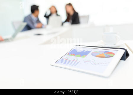 Tavoletta digitale che mostra i dati grafico su schermo in sala riunioni Foto Stock