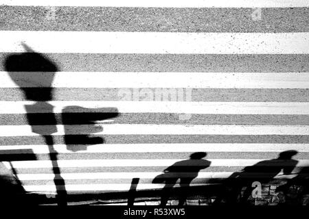 Sfocata le ombre dei pedoni waiing a zebra sreet incrocio con semaforo Foto Stock