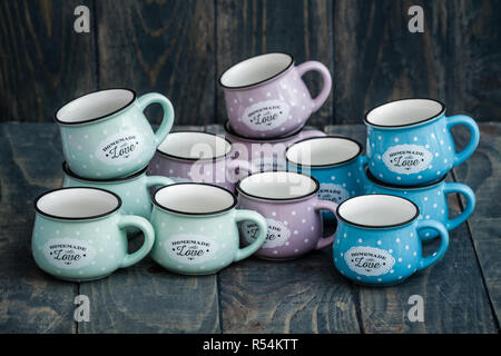 Ceramiche colorate tazze con lo smalto guardare Foto Stock