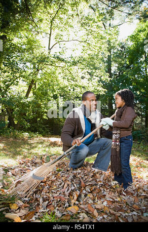 Padre e figlia a rastrellare foglie Foto Stock