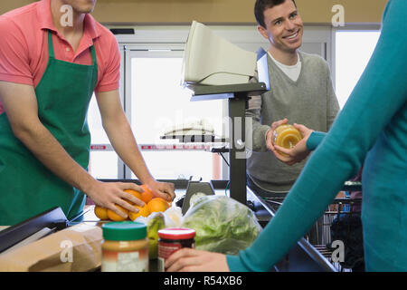 La famiglia presso un supermercato checkout Foto Stock