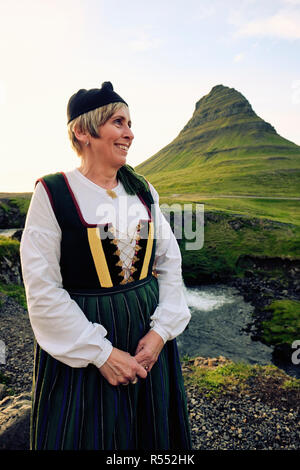 Un locale islandese di donna che indossa Upphlutur tradizionale abito nazionale a Mt Kirkjufell & Kirkjufellsfoss in Grundarfjörður - Snaefellsnes Islanda Europa Foto Stock