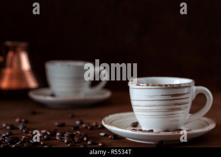 Sul tavolo sono due tazze di caffè e un turco con infuso di caffè. Foto Stock