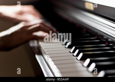 Lucido classica tastiera di pianoforte con il pianista le mani del giocatore la riproduzione in background Foto Stock