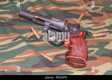 Revolver su sfondo di mimetizzazione. Pistola pneumatica 4,5 mm Foto Stock
