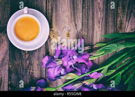 Tazza di caffè e un mazzo di iridi blu Foto Stock