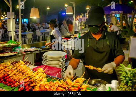 Stand alimentari venditore la preparazione di spiedini di carne in la cicala mercato del weekend, Hua Hin, Thailandia Foto Stock