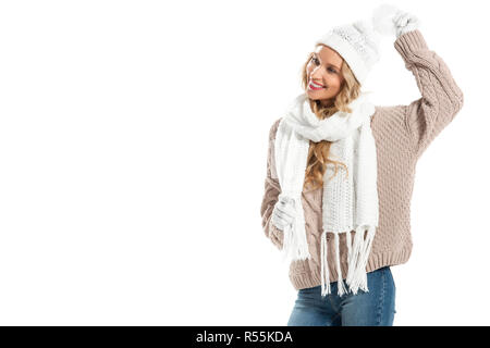 Allegro giovane donna in beige felpa lavorata a maglia, bianca cappello, guanti e sciarpa sorridente isolato su bianco Foto Stock