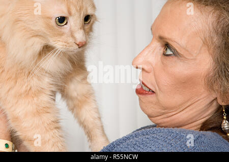 Donna senior con pet cat Foto Stock