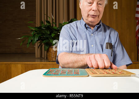 Senior uomo giocando a bingo Foto Stock