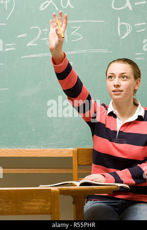 Studentessa con la sua mano alzata Foto Stock