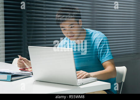 Uomo che utilizza un notebook con pasti da asporto Foto Stock