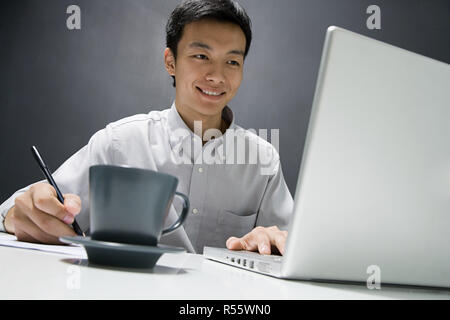 Uomo al lavoro su laptop Foto Stock