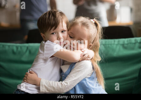 Piccolo fratello abbracciando sconvolto sorella seduta sul lettino Foto Stock