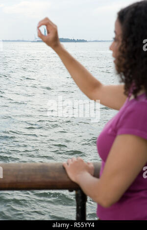 Donna cerchiare la statua della libertà con la mano Foto Stock