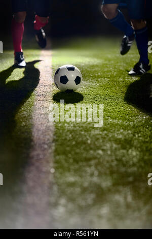 Due giocatori di calcio che corre verso il pallone da calcio Foto Stock
