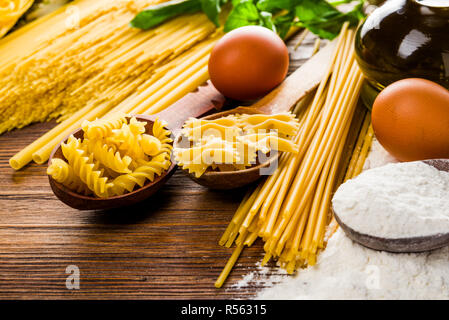 Tavolo da cucina durante la cottura il pollo con le uova e la farina e olio d'oliva e basilico Foto Stock