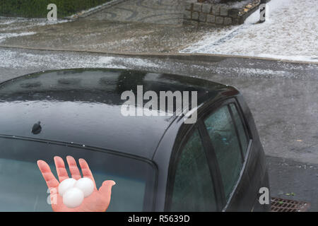 Grande grandine sfere di ghiaccio sul cofano auto dopo una forte tempesta di grandine Foto Stock