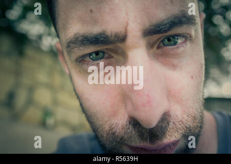 Chiudere su ritratto sulla faccia di un giovane con un espressione seria Foto Stock