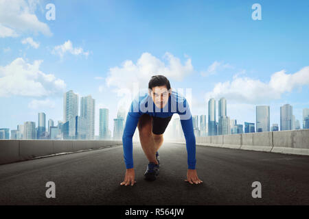 Sportivo da uomo asiatico runner ottenere pronto per la marcia su strada Foto Stock