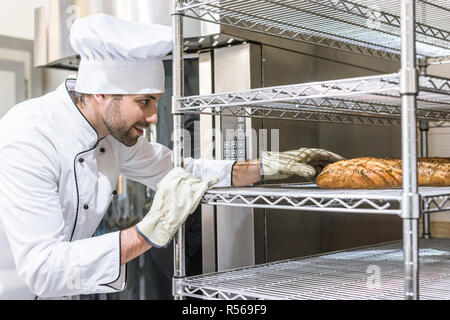 Vista laterale del panettiere guanti prendendo il pane Foto Stock