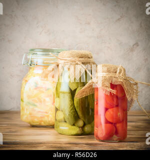 Set di verdure fermentate in vasi in legno tavolo rustico. Insalata di cavolo crauti cetrioli sottaceto pomodori ciliegia concetto trend alimentari dieta vegetar Foto Stock