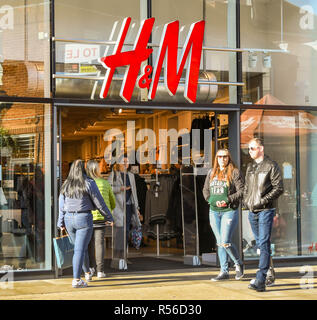 WINDSOR, Inghilterra - Novembre 2018: Segno sopra l'entrata di un ramo del rivenditore di abiti H&M a Windsor in centro città. I clienti stanno entrando nella stor Foto Stock