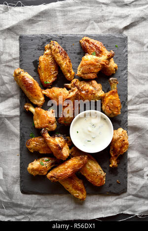 Arrosto di ali di pollo con salsa sulla scheda di ardesia. Vista superiore, laici piatta Foto Stock