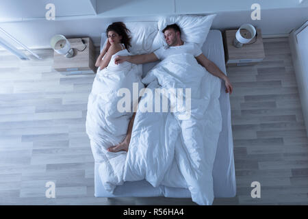 Coppia giovane che dorme sul letto Foto Stock
