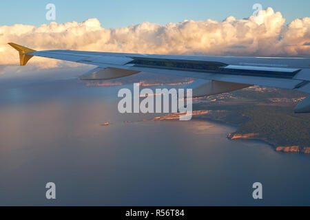 Uno scenario pittoresco alla costa rocciosa, Mediterraneo Seascape e soffici nuvole sopra la terra vista dalla finestra di aeroplano Foto Stock