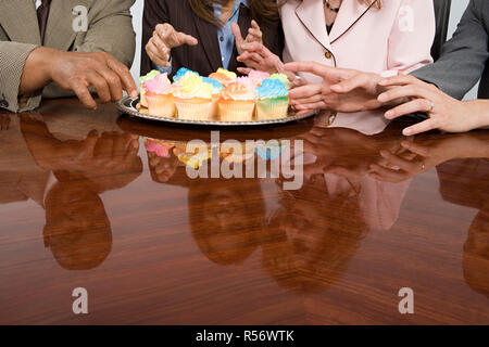 Gli imprenditori di raggiungere per i tortini Foto Stock