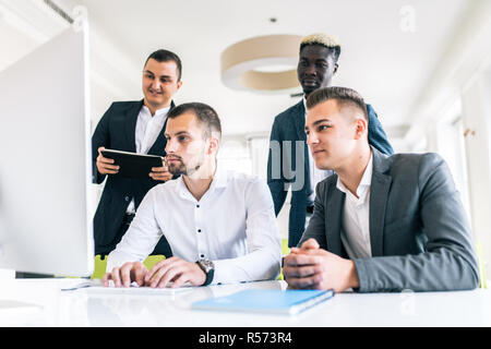 Concentrate il team Aziende a discutere insieme di presentazione in ufficio. Grave multietnica di giovani esperti aziendali preparazione del report e discutere di strat Foto Stock