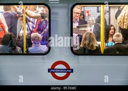 Londra Inghilterra,Regno Unito,Westminster,St James's Park stazione della metropolitana treno metro, metropolitana piattaforma, treno affollato, pendolari passeggeri, uomo m Foto Stock