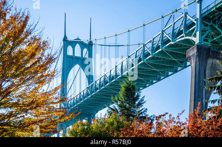 Famoso gothic St Johns ponte che attraversa il fiume Willamette in Portland area industriale con supporto arcuato pilastri circondato da autunno alberi colorati Foto Stock