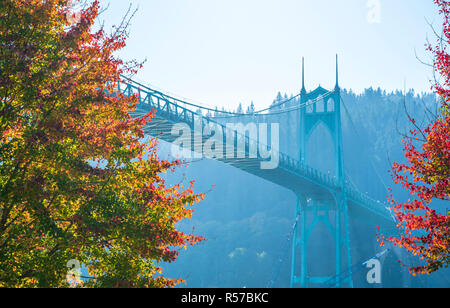 Famoso gothic St Johns ponte che attraversa il fiume Willamette in Portland area industriale con supporto arcuato pilastri circondato da autunno alberi colorati Foto Stock