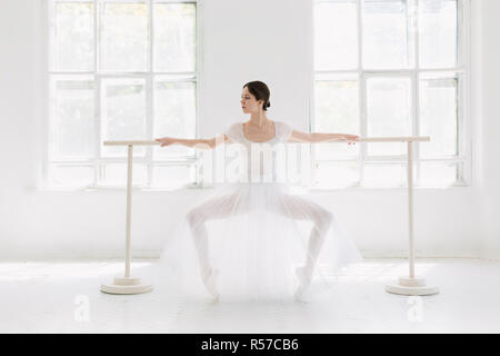 Giovane e incredibilmente bella ballerina è in posa e balli in un bianco studio Foto Stock