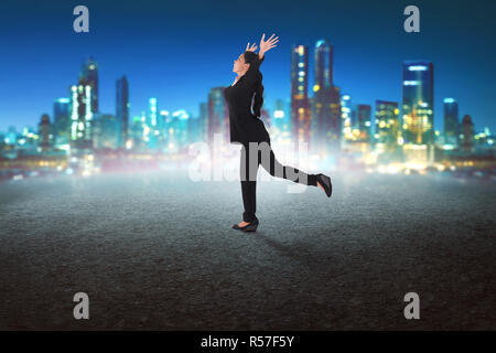Felice asian business woman in esecuzione in strada concreta Foto Stock