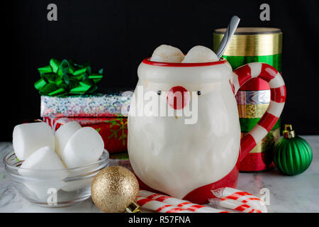 Babbo Natale tazza con cioccolata calda & Marshmellows con la caramella canne e bastoni di menta piperita presenta fiocchi di raso e Marshmellows fresco Foto Stock