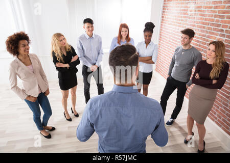 Manager di conversazione con i suoi colleghi di lavoro Foto Stock