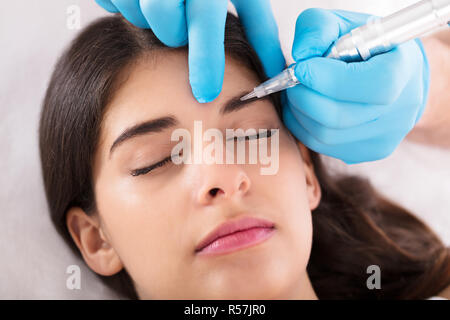 Cosmetologo applicare trucco permanente sulle sopracciglia Foto Stock