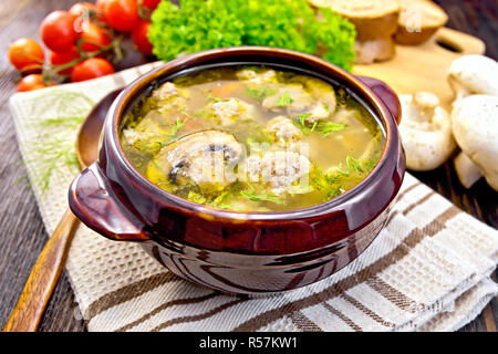 Zuppa con polpette di carne e funghi in ciotola marrone sul bordo scuro Foto Stock