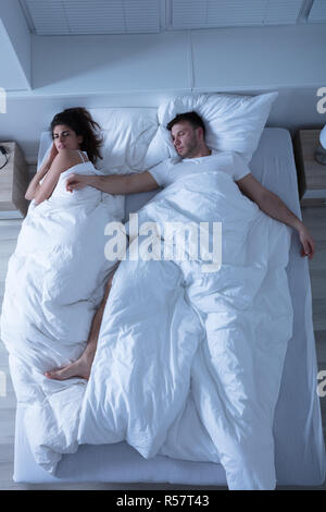 Coppia giovane che dorme sul letto Foto Stock