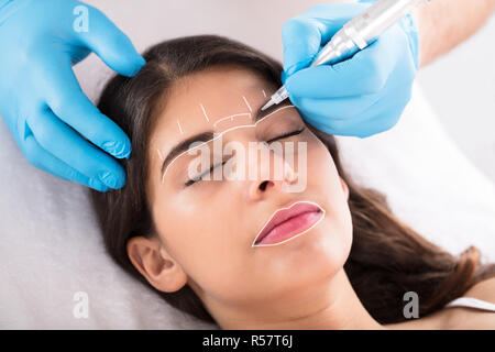 Cosmetologo applicare trucco permanente sulle sopracciglia Foto Stock