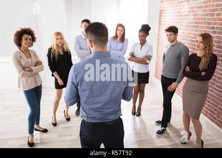 Manager di conversazione con i suoi colleghi di lavoro Foto Stock