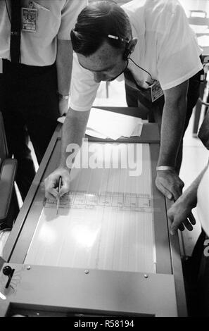 S69-39588 (20 luglio 1969) --- Il Dottor Garry Latham, con il Lamont Osservatorio geologico, studi tracciati sismometrica nel Mission Control Center?s'ASEP sala di controllo. I dati elettronici è stata proveniente dal passivo esperimenti di sismica pacchetto che l'Apollo 11 astronauti avevano appena distribuito sulla superficie della luna. Foto Stock